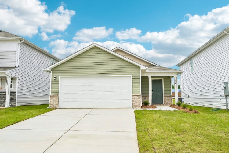 A house with garages and grass.