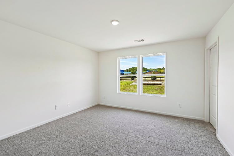 A room with a window and a carpet.
