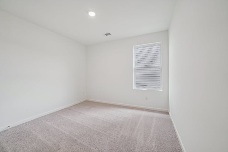 A room with a carpet and a door.