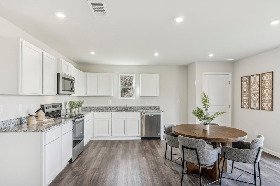 A kitchen with white cabinets.