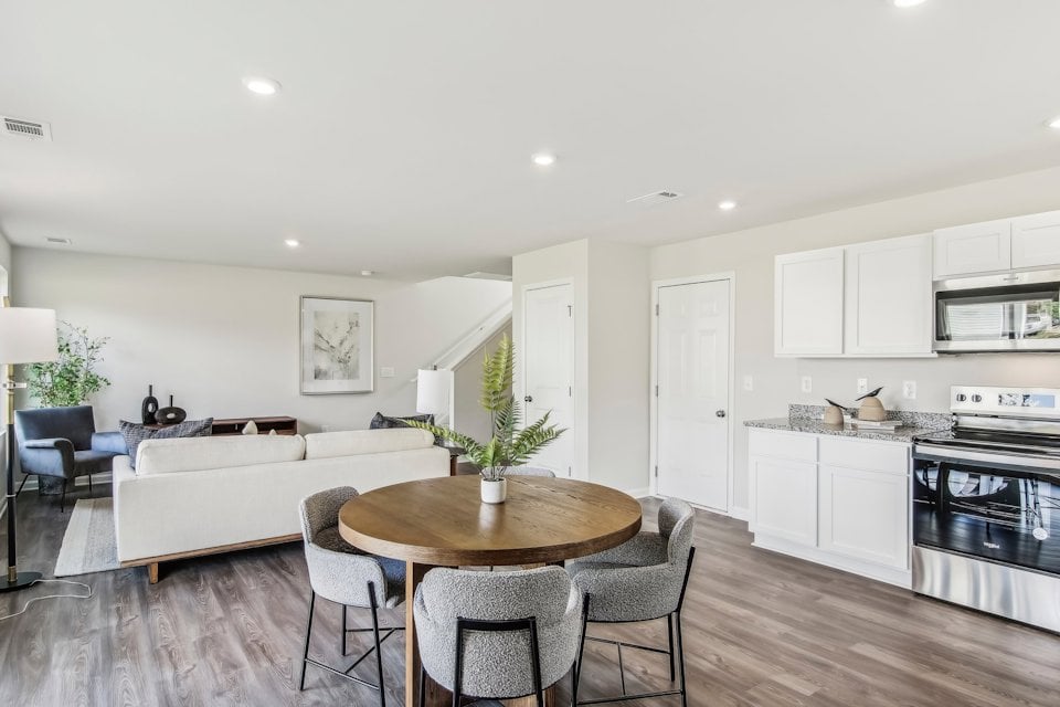 A kitchen with a table and chairs.