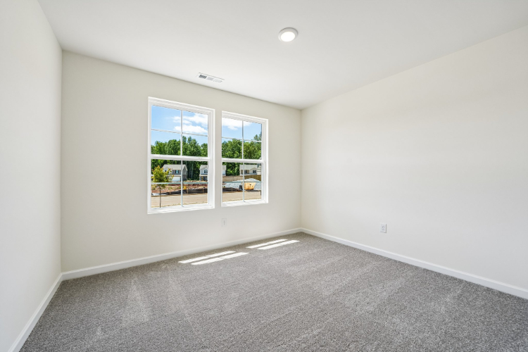 A room with a window and a carpet.