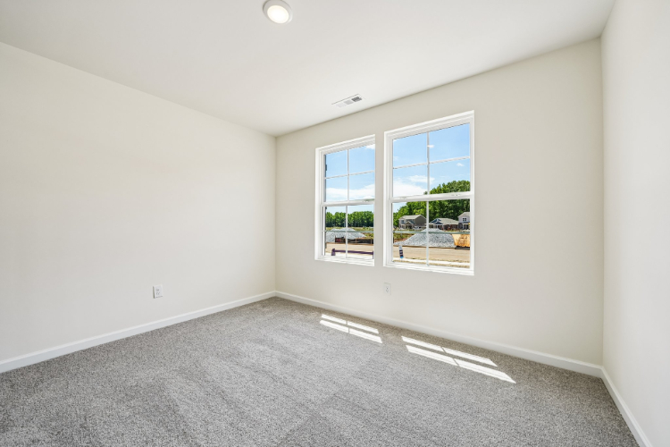 A room with a window and a carpet.