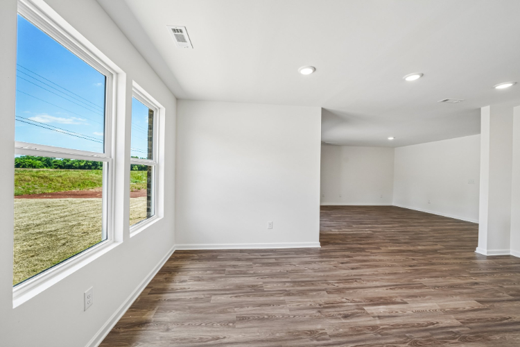 A room with windows and a wood floor.