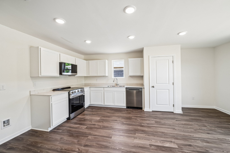 A kitchen with white cabinets.