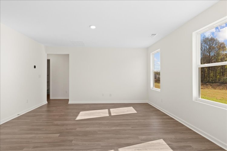 A room with a wood floor and a wood floor with a white rug.