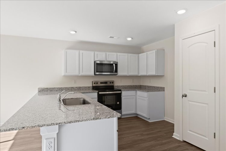 A kitchen with white cabinets.