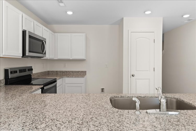 A kitchen with marble counters.