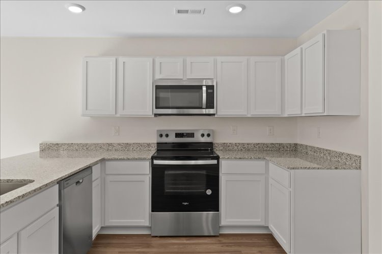 A kitchen with white cabinets.