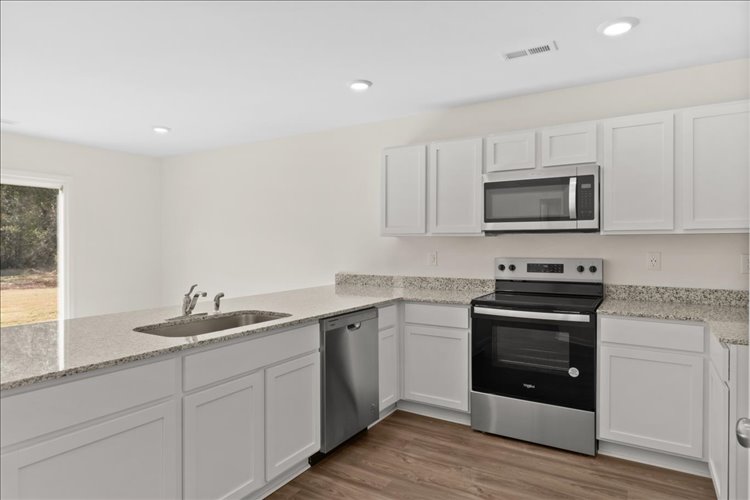 A kitchen with white cabinets.