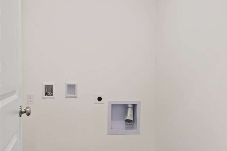 A white wall with a light switch.