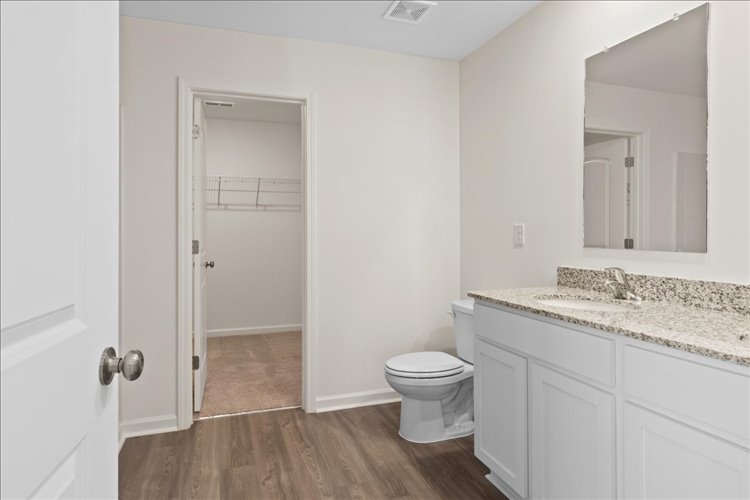 A bathroom with white cabinets.