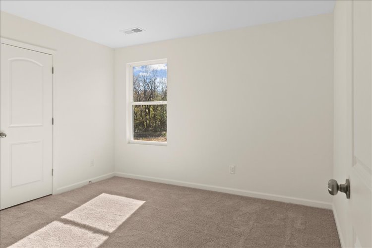 A room with a window and a rug.