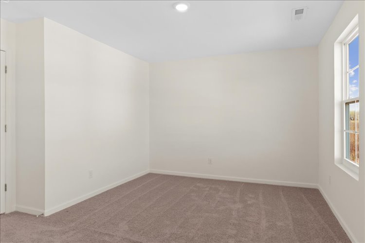 A room with a carpet and a window.