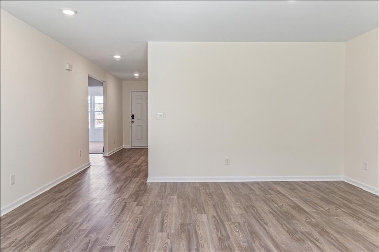 A room with a wood floor and white walls.