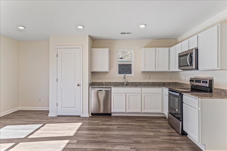 A kitchen with white cabinets.