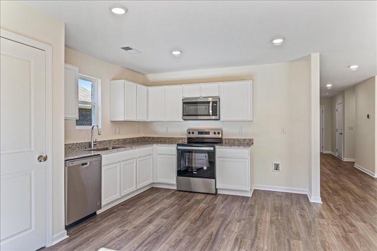 A kitchen with white cabinets.