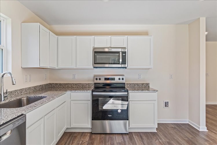 A kitchen with white cabinets.
