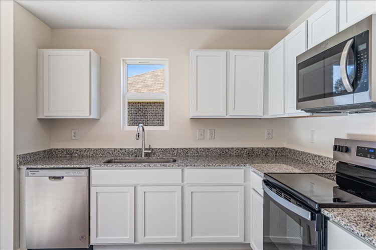 A kitchen with white cabinets.