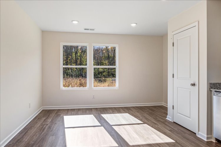 A room with a wood floor and windows.
