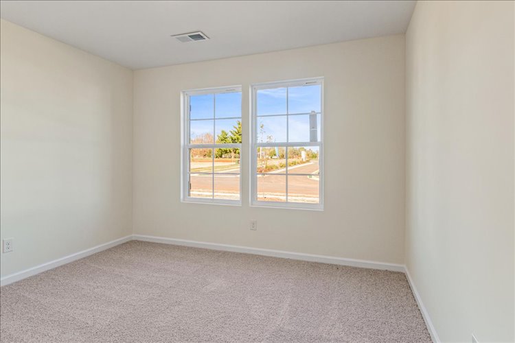 A room with a window and carpet.
