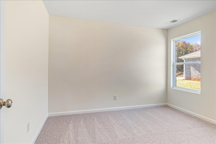 A room with a window and carpet.