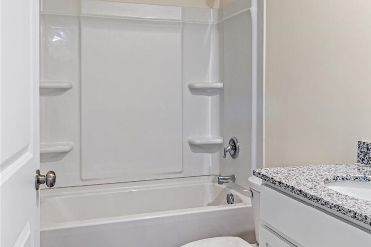 A bathroom with a bathtub sink and a shower unit.