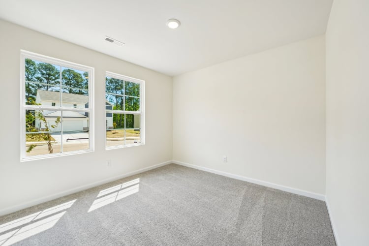 A room with windows and a white wall.