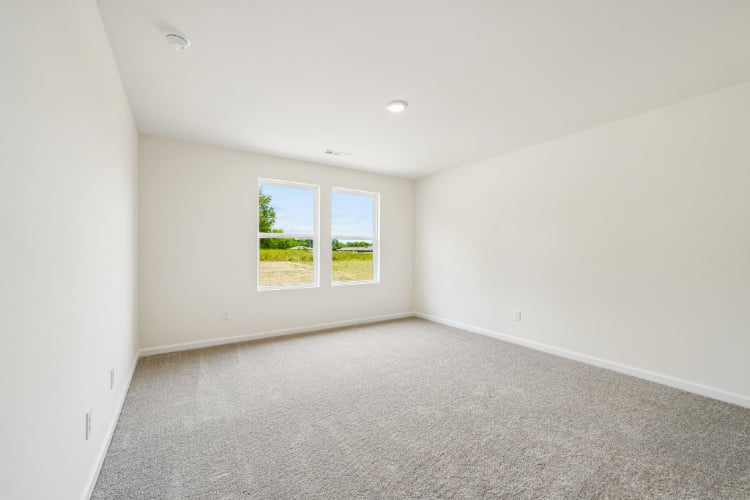 A room with a window and carpet.
