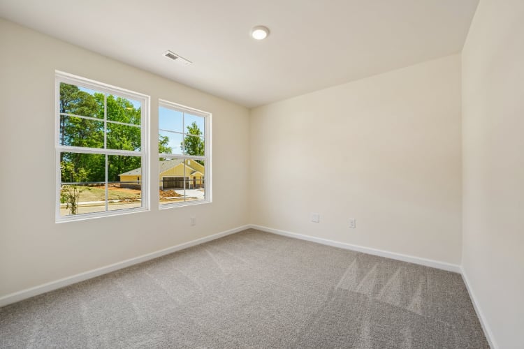 A room with a window and a carpet.