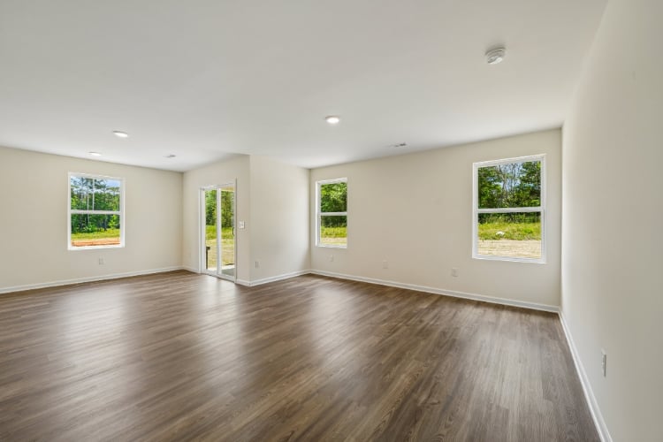 A room with windows and wood floors.