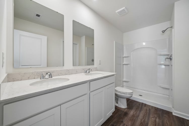 A bathroom with white cabinets.