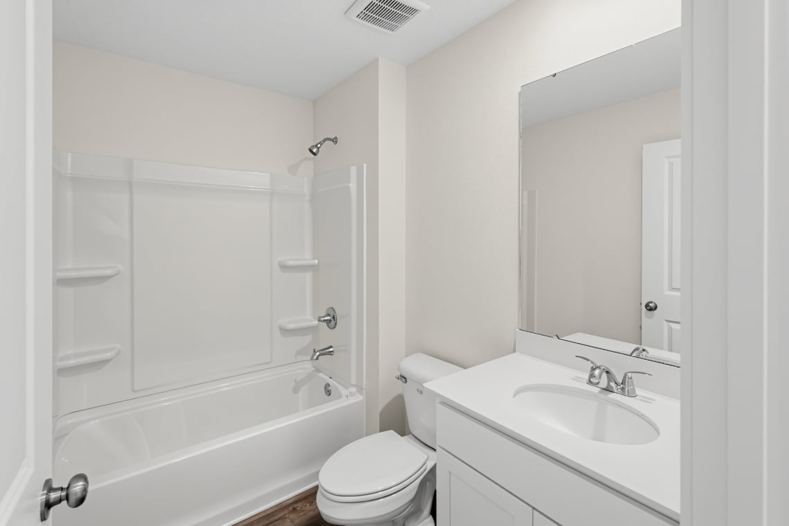 A bathroom with a tub sink and toilet.