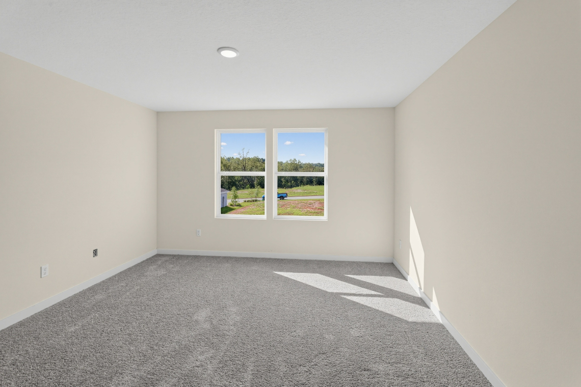 A room with a window and carpet.