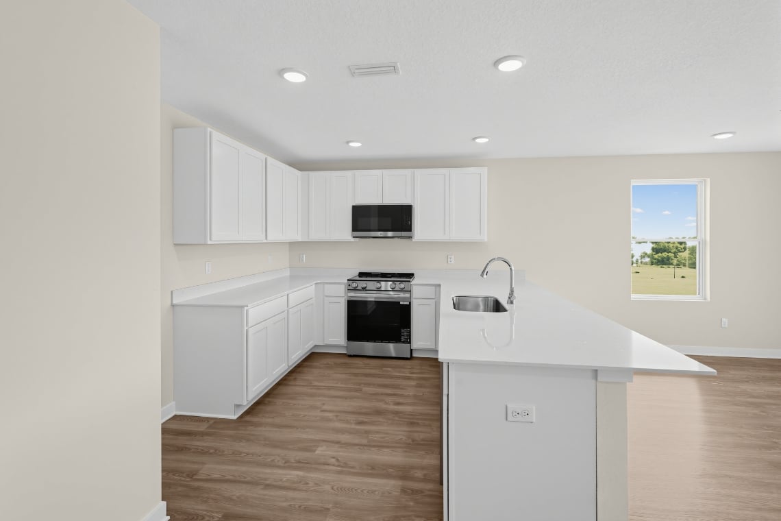 A kitchen with white cabinets.