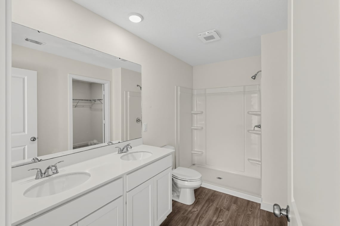 A bathroom with a toilet sink and mirror.