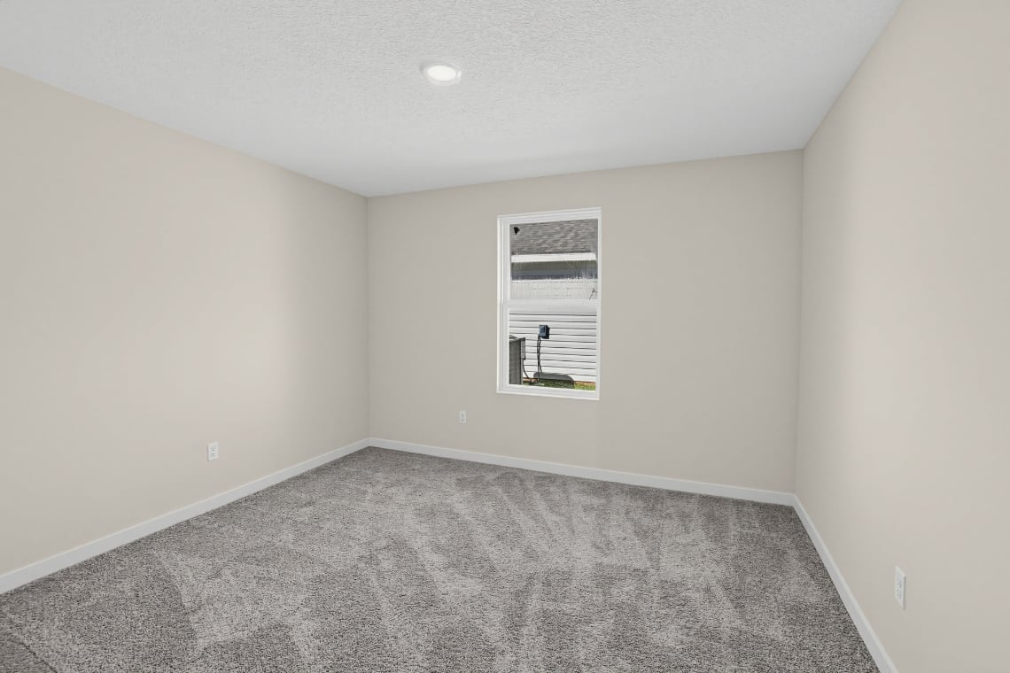 A room with a carpet and a window.