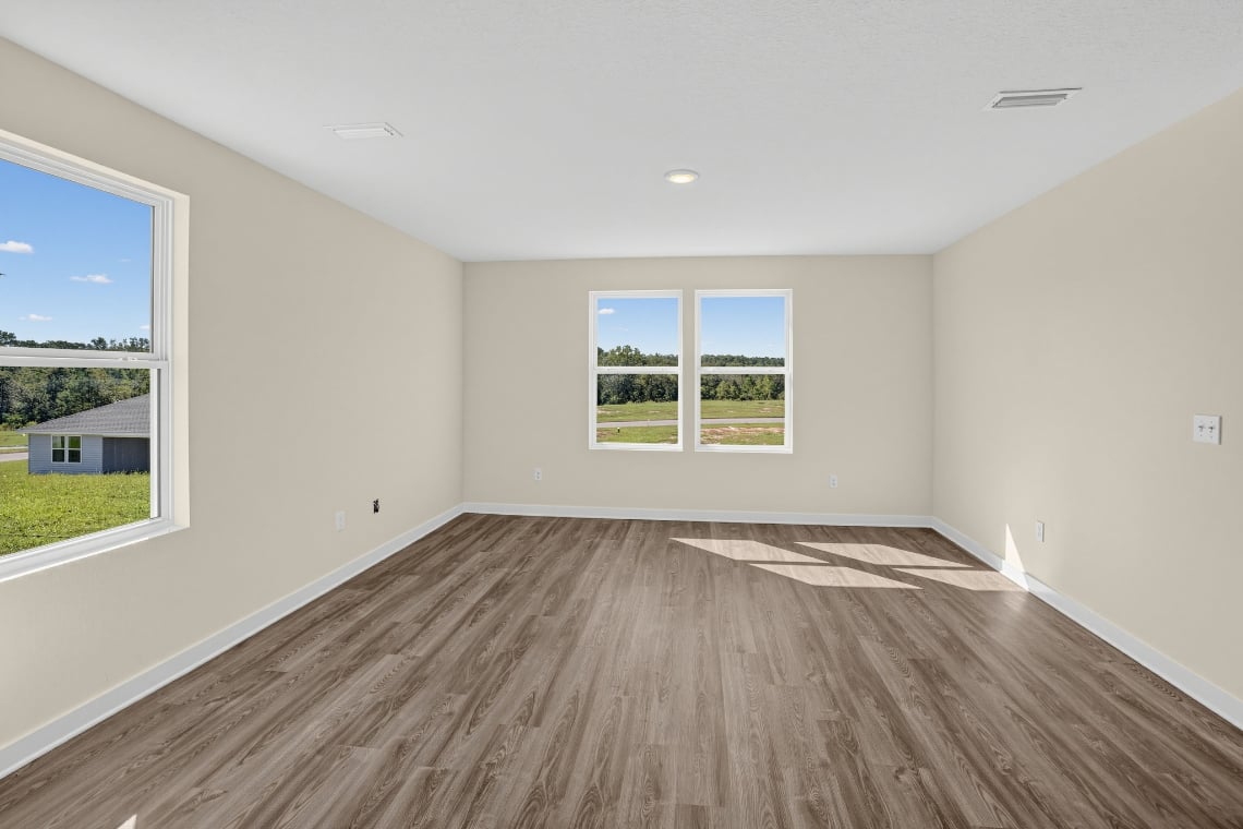 A room with a wood floor and windows.