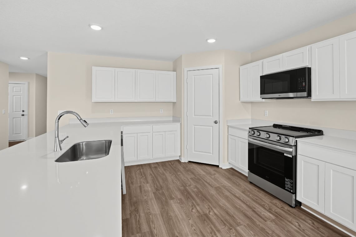 A kitchen with white cabinets.