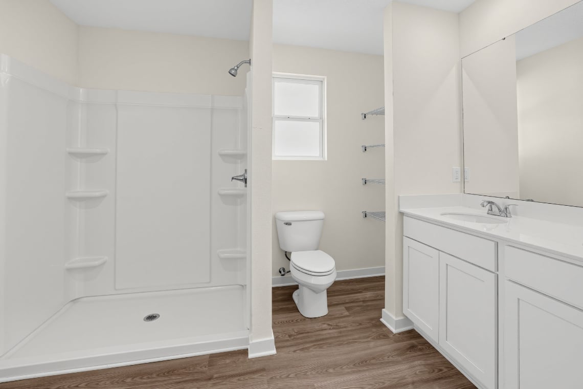 A bathroom with white cabinets.