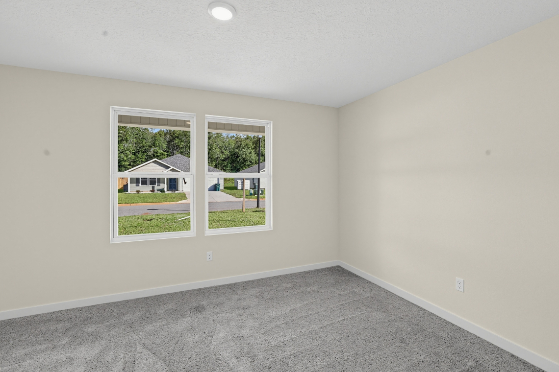 A room with a window and a carpet.