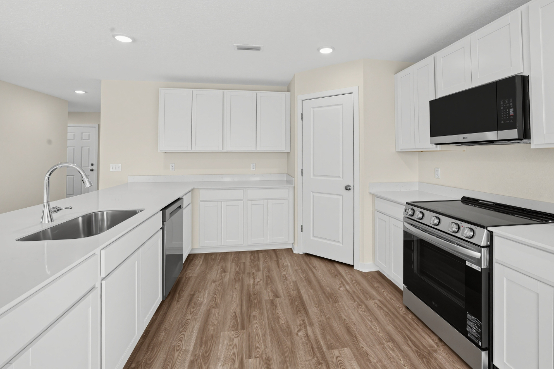 A kitchen with white cabinets.
