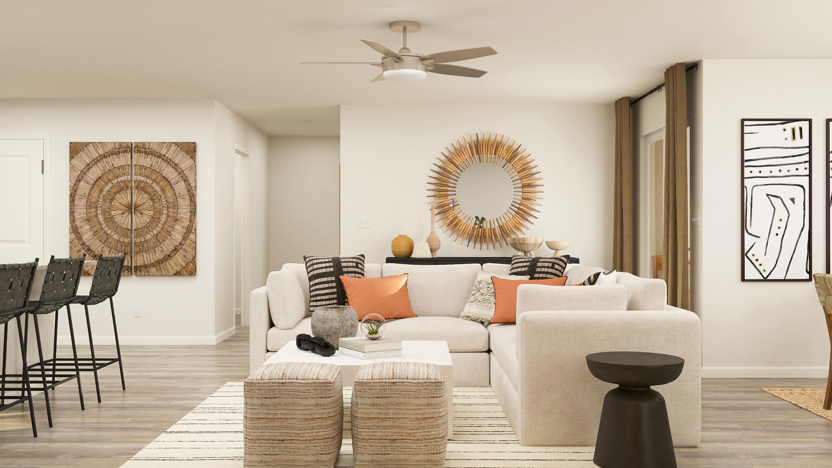 A living room with a white couch and a round mirror.