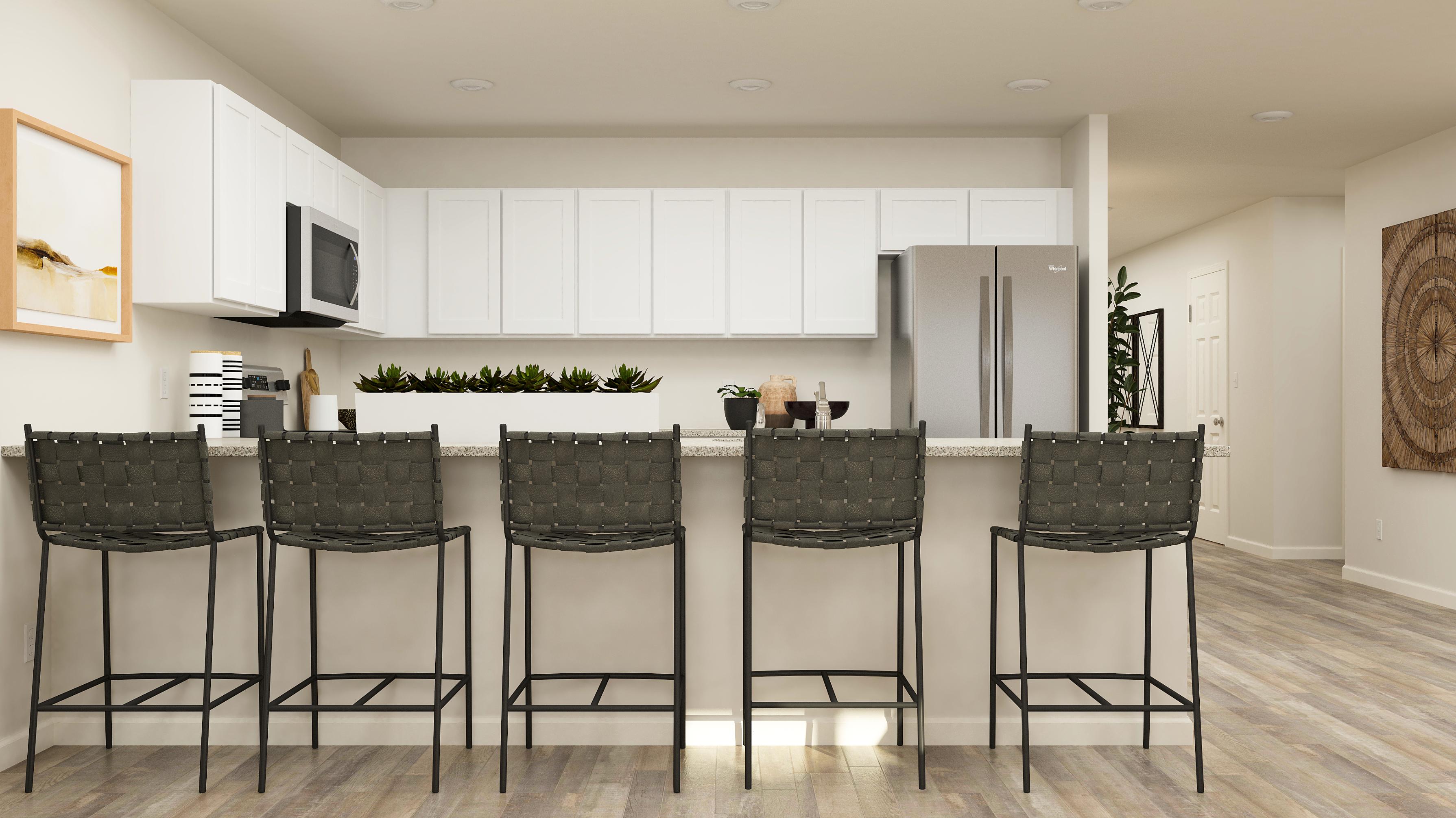 A kitchen with a table and chairs.