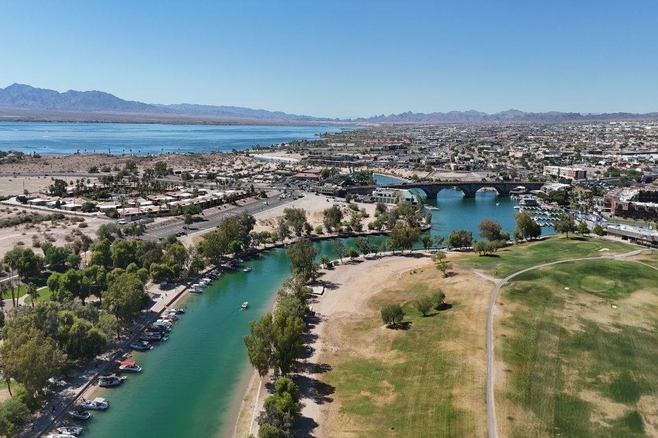 A landscape with a body of water and buildings by it.