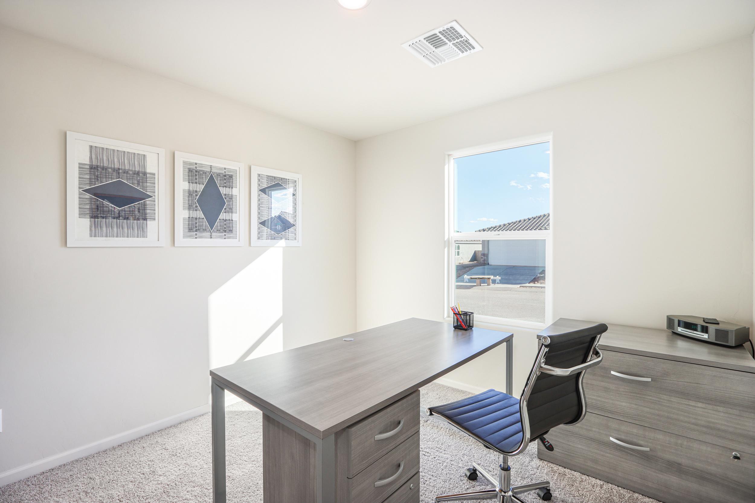 A room with a desk and chairs.