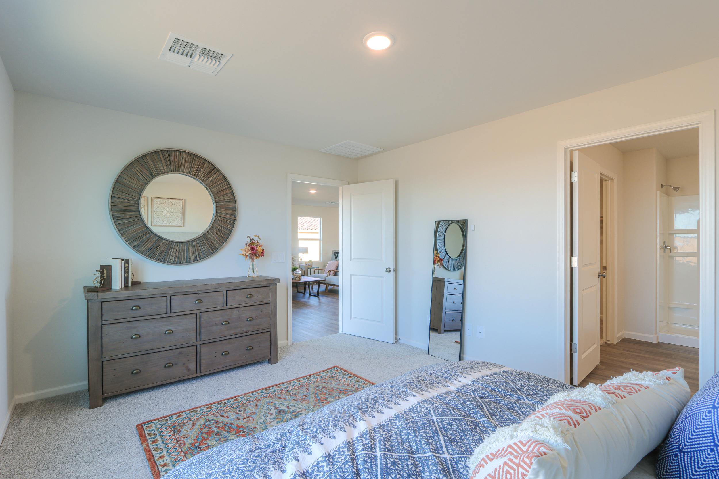 A bedroom with a bed and dresser.