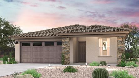 A house with a garage and bushes in front of it.