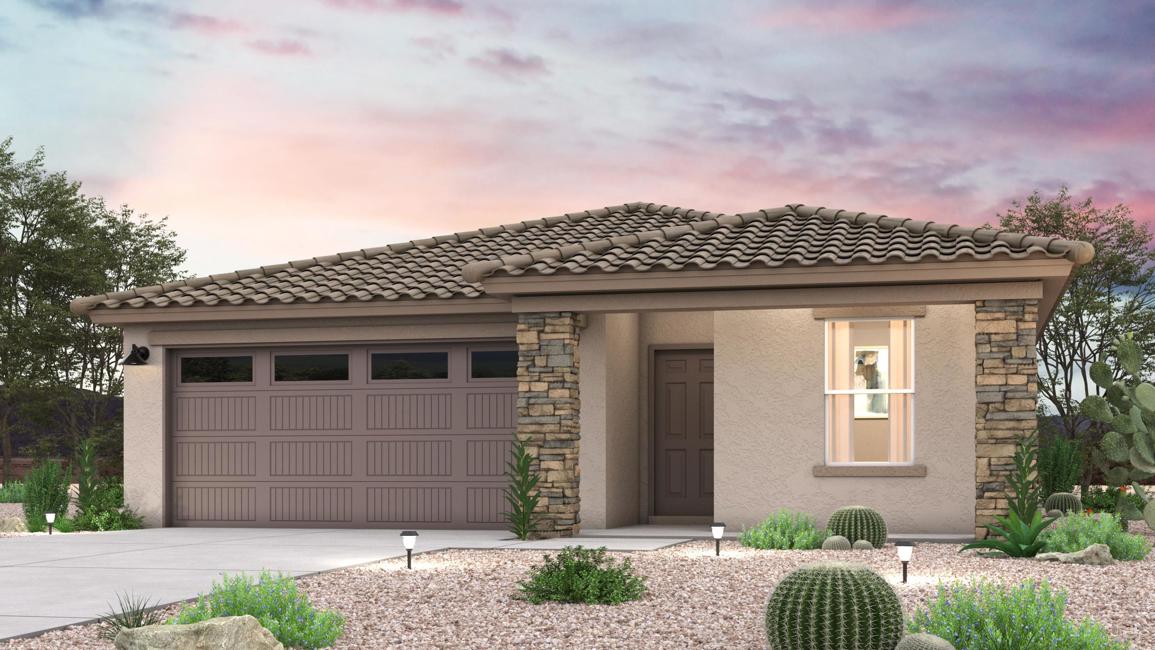 A house with a garage and bushes in front of it.
