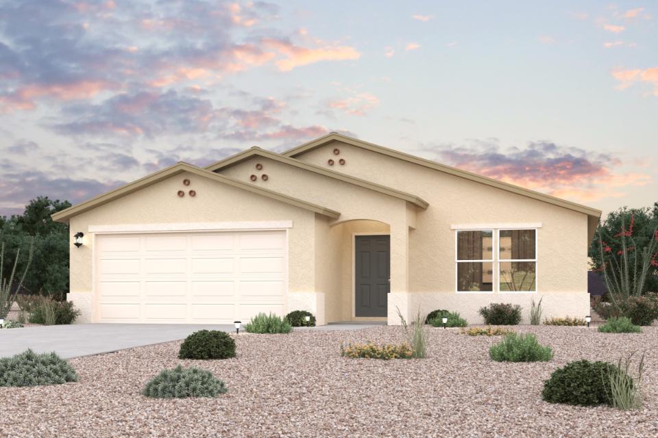A house with a garage and bushes in front of it.
